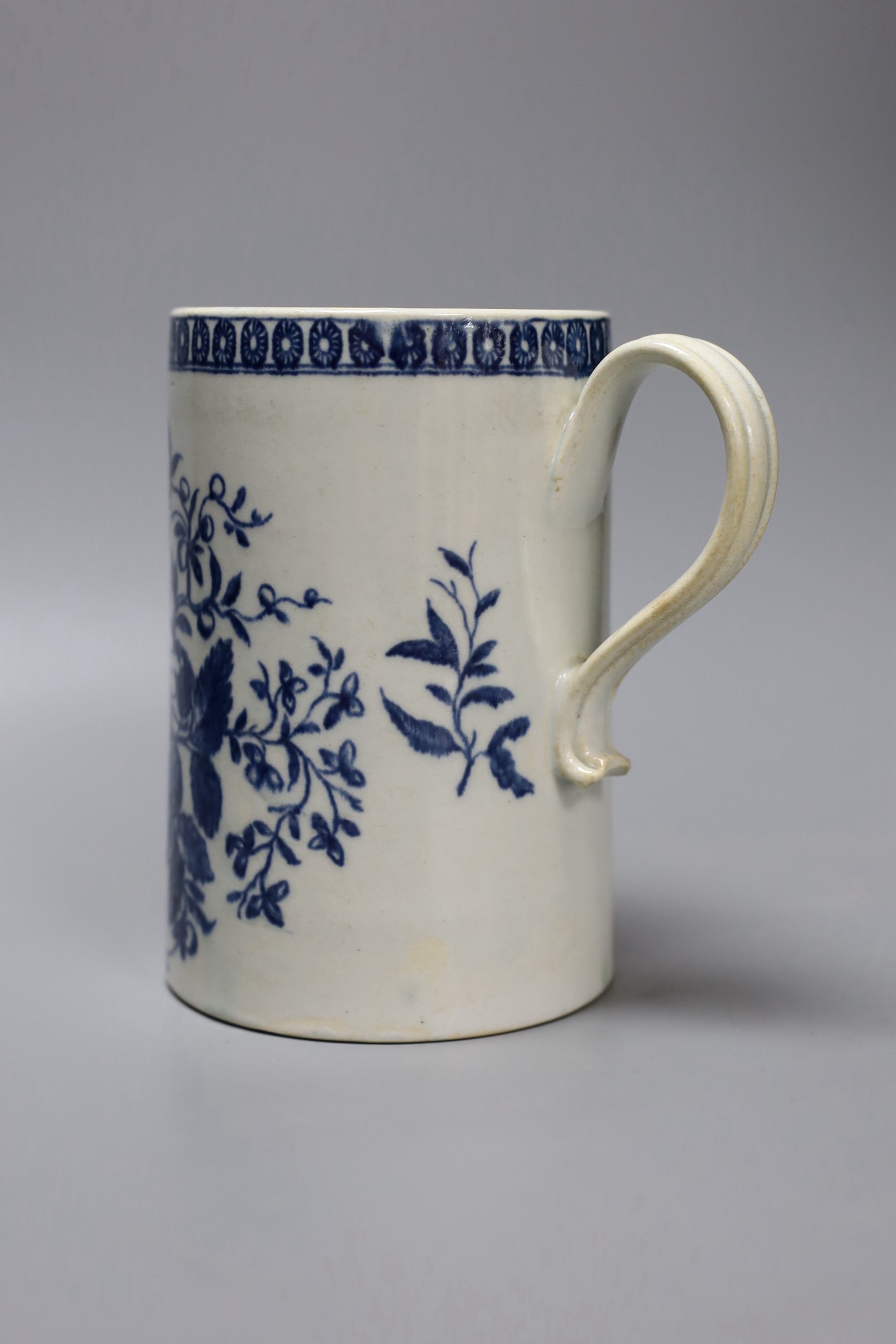 A Liverpool mug, decorated in blue underglaze with flowers and a cell border, 16cm